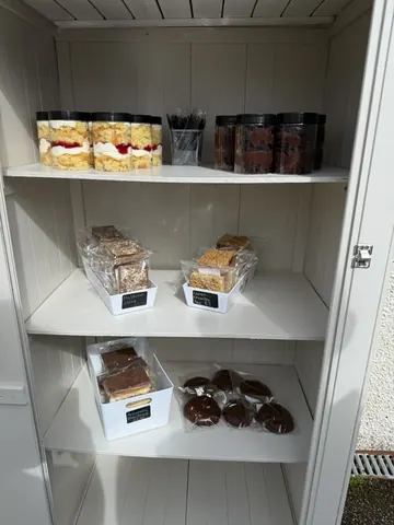 A white shelf with a variety of food items on it.
