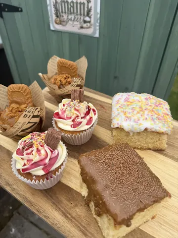 A wooden table with a variety of desserts on it.