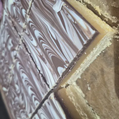 A piece of cake with white and brown stripes.