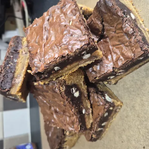 A stack of brownies with white frosting.