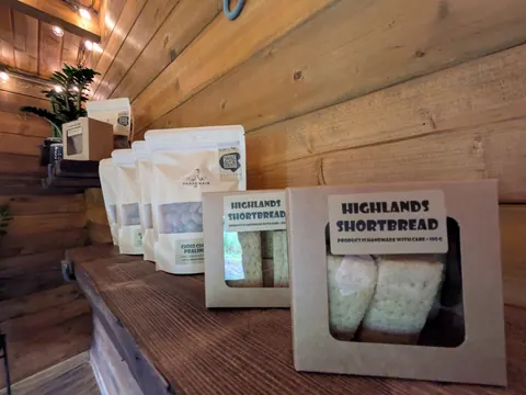 A wooden shelf with a variety of bags and boxes on it.