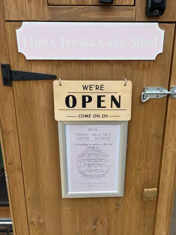 A sign that says "We're open" on a wooden door.