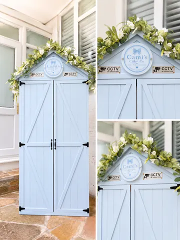 A blue shed with a white bow on top.
