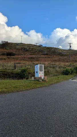 A white box with a heart on it is sitting on a road.