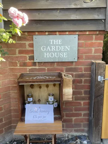 A wooden box with a sign that says "The Garden House" on it.
