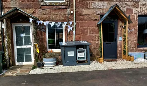 A small building with a sign that says "Compton Castle" on it.