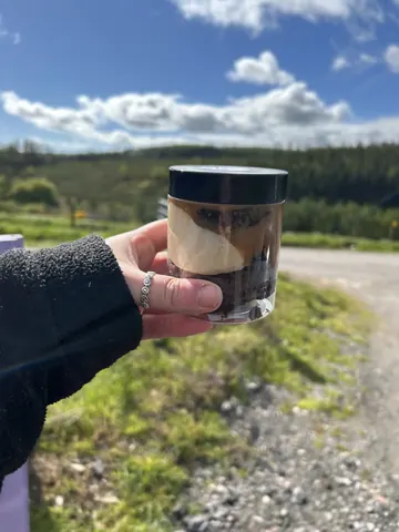 A person holding a jar of food.