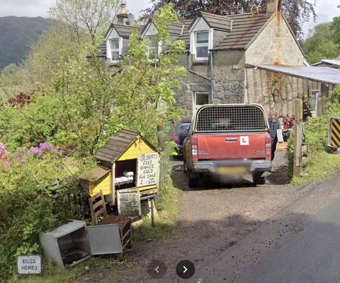 A red truck is parked in front of a house.