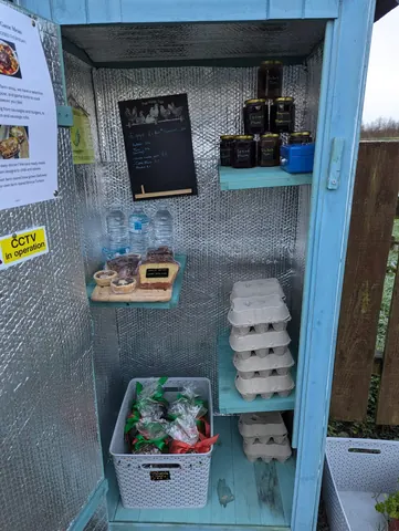 A refrigerator with eggs and water bottles inside.