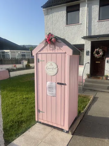 A pink shed with a sign on it.