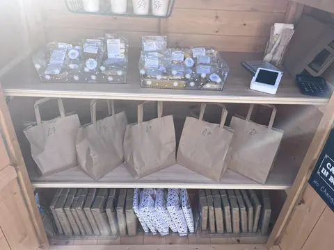 A wooden shelf with bags on it.