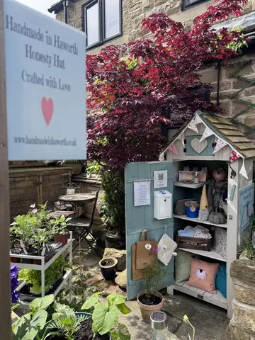 A small blue shed with a sign that says Honesty Hut.