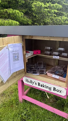 A pink box with a sign that says "Holly's Baking Box" and a sign that says "QR code".