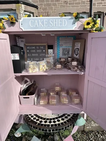 A pink cabinet with a sign that says "welcome to the cake shed".