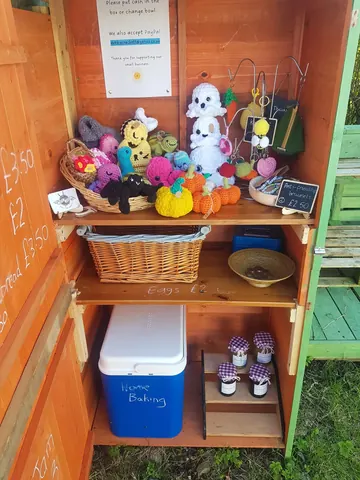 A small wooden structure with a blue cooler inside.