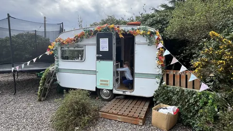 A white trailer with a girl inside.
