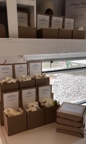 A stack of boxes with a leaf on the window sill.