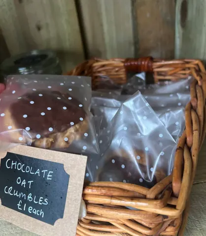 A basket of food with a sign that says chocolate oat crumbles.