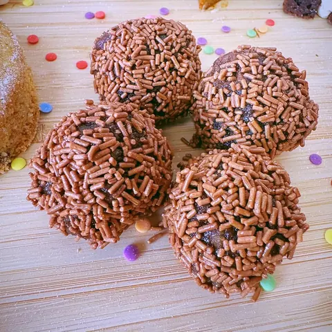 A table with three chocolate covered balls on it.