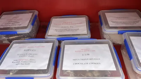 A red table with several containers of food on it.