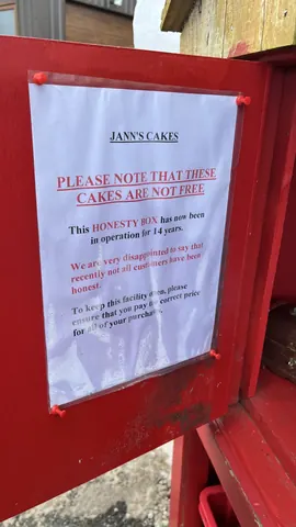 A sign on a red wall that says "Jann's Cakes".