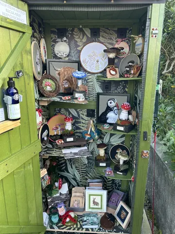 A green cabinet with a lot of stuff in it.