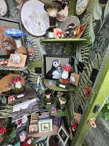 A collection of various items, including a mushroom, a bird, and a picture of a tree, are displayed on a table.