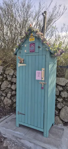 A blue shed with a sign on the door.
