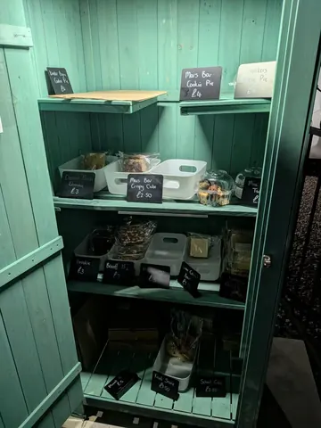 A green cabinet with a white shelf inside.
