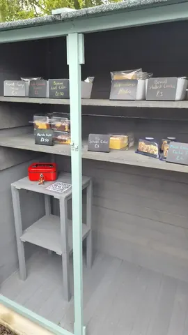 A red suitcase is sitting on a shelf.