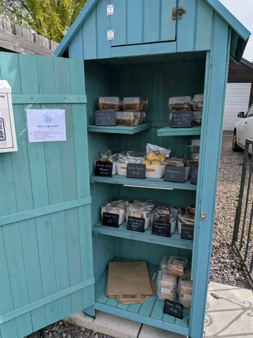 A blue wooden box with a sign on it.