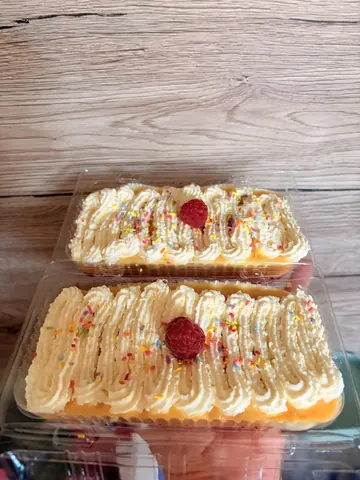 Two cakes with frosting and sprinkles on a table.