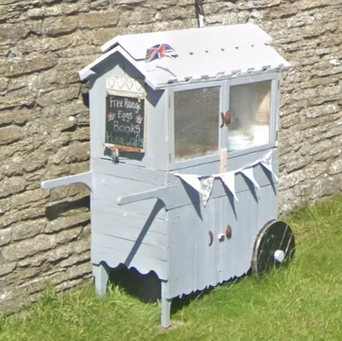 A small white building with a sign on it.