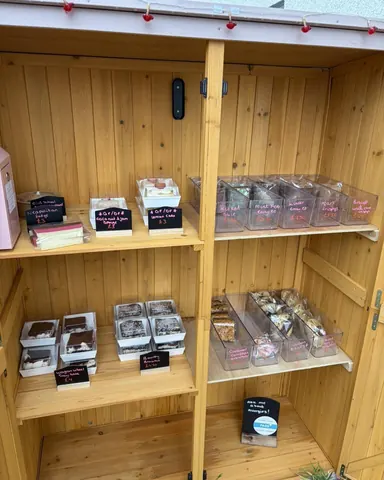 A wooden shelf with a sign that says "Cakes" on it.