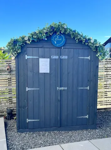 A blue shed with a white heart on it.