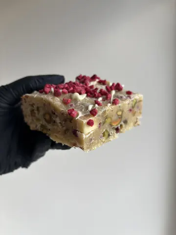 A hand holding a piece of food.
