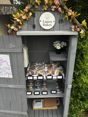 A small wooden shelf with a sign that says "Laura Bakes" on it.
