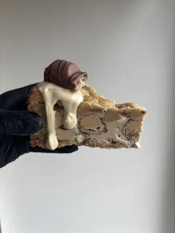 A hand holding a piece of cake.
