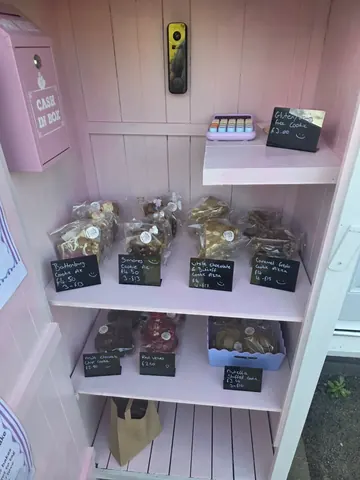 A pink shelf with a sign that says "Cake".
