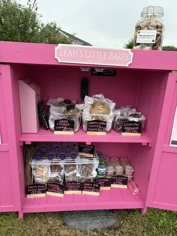 A pink box with a sign that says "Leah's Little Bakery" on it.