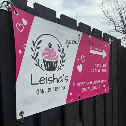 A pink sign with a cupcake on it.