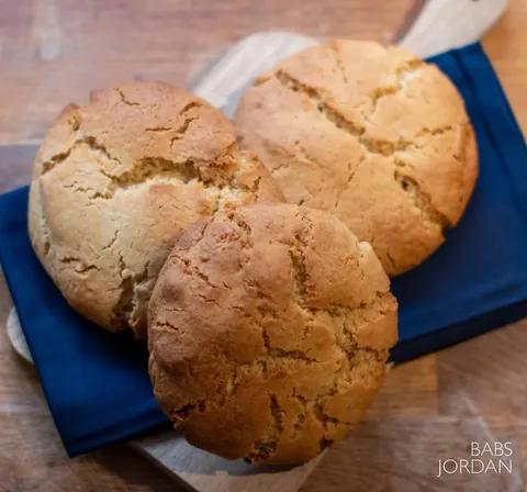 A wooden table with three cookies on it.