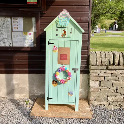 A small blue house with a wreath on the door.
