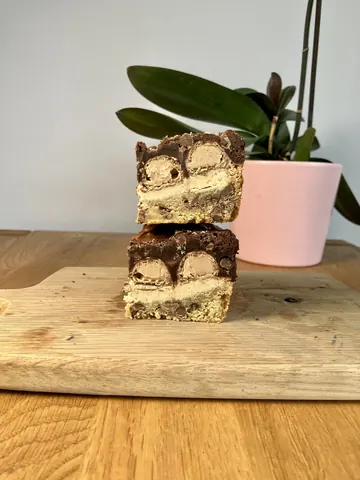 A piece of cake is on a cutting board.