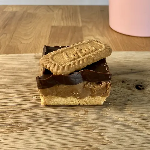 A cookie with a chocolate chip and a peanut butter cookie on top.
