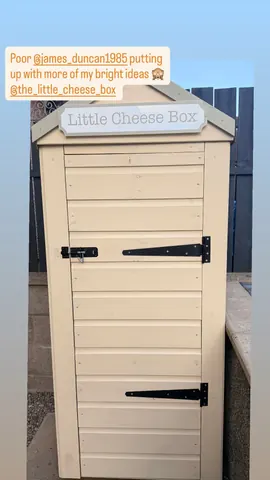 A small white shed with a sign on it that says "Little Cheese Box."