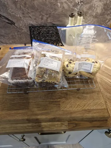 A table with a bag of cookies and a bag of brownies on it.