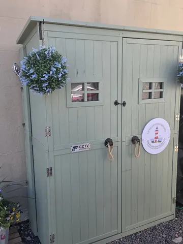 A green door with a white sign on it.