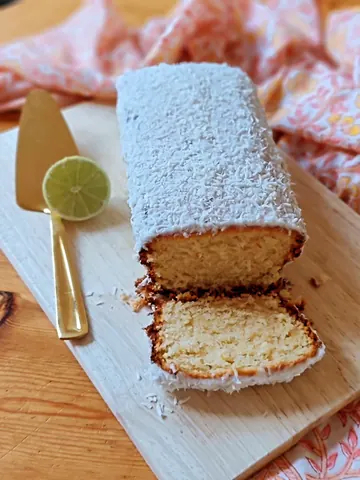 A slice of cake on a wooden board.