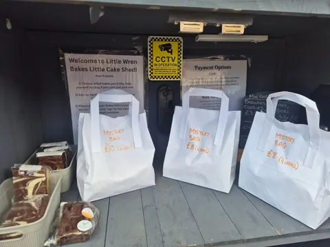 Three white bags with orange writing on them.